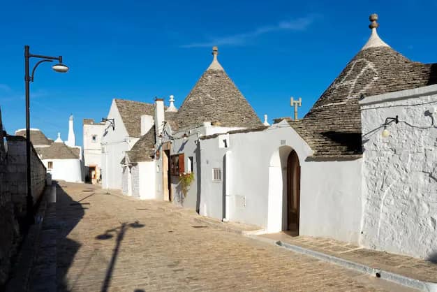 A street of whitewashed trulli houses with conical stone roofs in Alberobello, Puglia