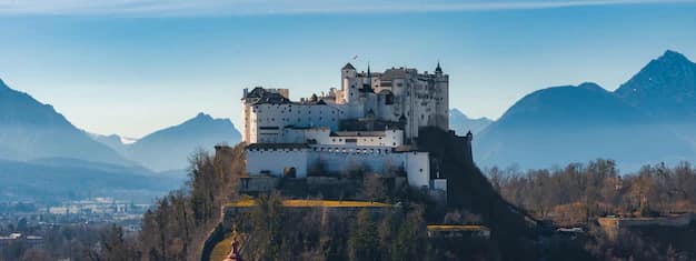 High-angle view of Hohensalzburg Fortress rising above the rooftops and church domes of Salzburg's old town