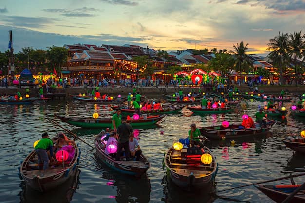 Silk lanterns and yellow houses on the Hoi An riverfront at sunset, Vietnam