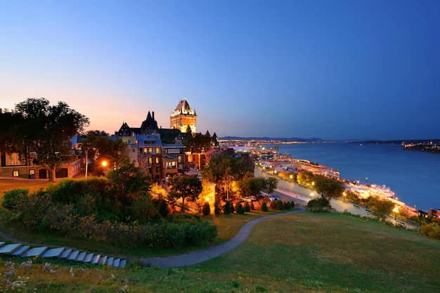 Quebec City skyline with the turreted Chateau Frontenac glowing at sunset above the St Lawrence River